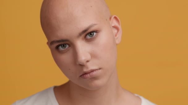 Allvarlig skallig rubrik kvinnlig Posing tittar på kameran över gul bakgrund — Stockvideo