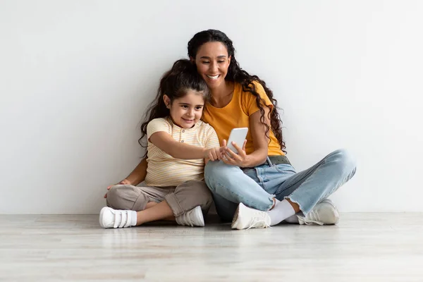 Kinderen en technologie. Klein meisje met behulp van smartphone met mama thuis — Stockfoto