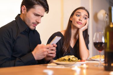 Unhappy Woman Bored On Date, Man Using Phone