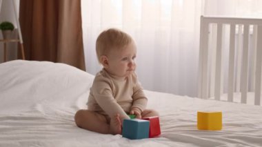 Baby Development. Cute Infant Child Playing With Colorful Building Blocks On Bed