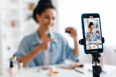 Unrecognizable Lady Making Video On Cellphone Showing Cosmetics Product Indoor