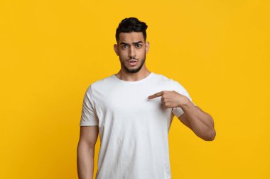 Confused young muslim guy pointing at himself