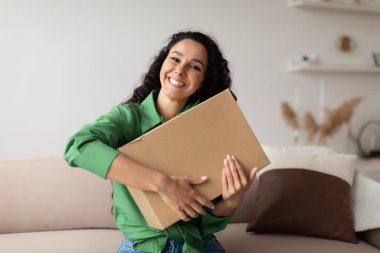Happy Shopaholic Lady Hugging Box Sitting On Sofa At Home