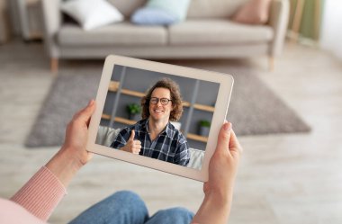 Female hands holding digital tablet, having video call with friend