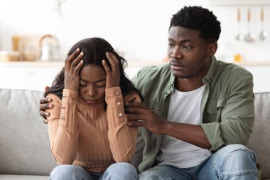 Sevgi dolu Afrikalı Amerikalı adam ağlayan karısını teselli ediyor.