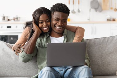 Sevilen siyah çift dizüstü bilgisayar kullanıyor, ev içi.