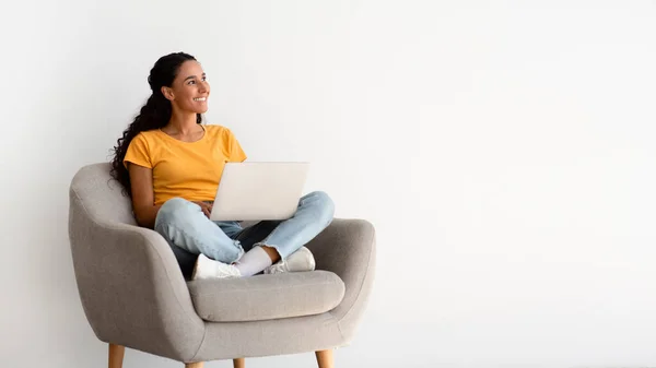 Online Offer. Smiling Young Woman With Laptop On Laps Sitting In Armchair —  Fotos de Stock