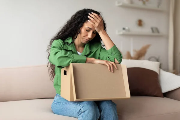 Frustrated Woman Buyer Unpacking Cardboard Box Siting On Couch Indoor — ストック写真