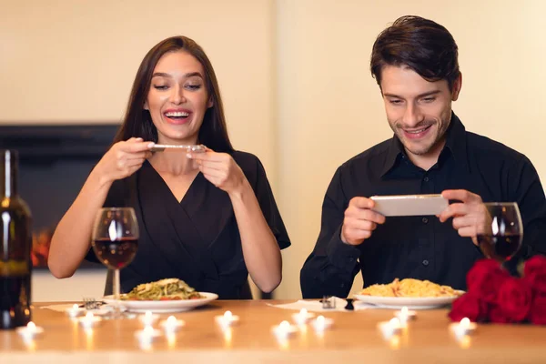 Sorrindo jovem casal tirando foto de comida — Fotografia de Stock