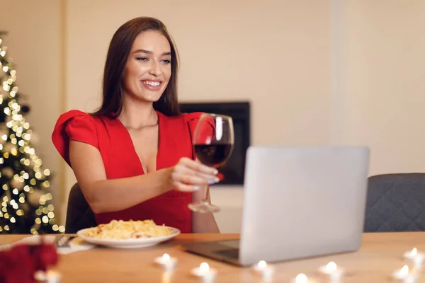 Excited woman having dinner during virtual date on laptop — 스톡 사진