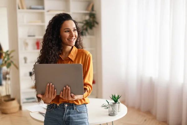 Woman Holding Laptop Working Online Standing Looking Aside Smiling Indoor — Φωτογραφία Αρχείου