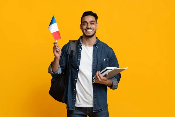 Cheerful arab guy with books and flag of France — Stockfoto