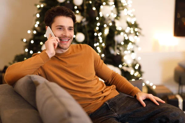 Fröhlicher Mann telefoniert auf Couch — Stockfoto