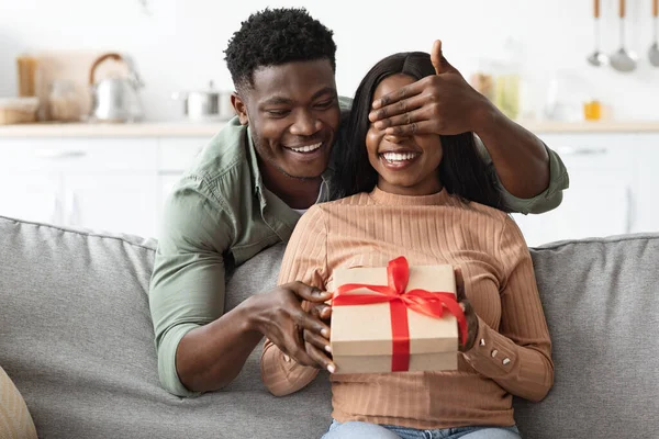 Amoroso afroamericano chico haciendo sorpresa para novia, dando regalo —  Fotos de Stock