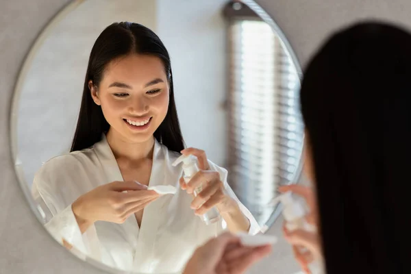 Senhora coreana bonita usando leite de limpeza, remoção de maquiagem — Fotografia de Stock