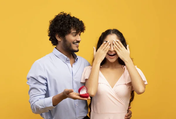Sorpresa increíble el día de San Valentín. Hombre indio cariñoso haciendo propuesta con anillo, chica cubriendo los ojos con palmas — Foto de Stock