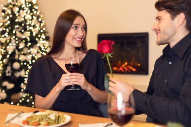 Genç yakışıklı bir adam kırmızı gül veriyor kadınlara