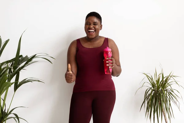 Positive black woman plus size with bottle of water — Stock Photo, Image