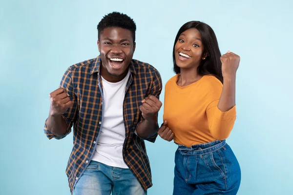 Portrait of excited young black couple shaking clenched fists — Stock Photo, Image