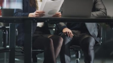 İş yerinde cinsel taciz. İş adamı iş arkadaşını taciz ediyor, masanın altında dizine dokunuyor.