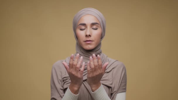 Concept de foi. Portrait studio de jeune femme musulmane paisible du Moyen-Orient portant le hijab traditionnel priant Dieu — Video