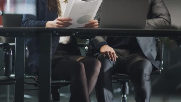 Assédio sexual no trabalho. Empresário assediar mulher colega durante a reunião, tocando o joelho debaixo da mesa — Vídeo de Stock