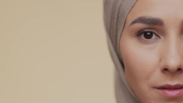 Halvt ansigt portræt af smukke muslimske mellemøstlige dame iført traditionel hijab søger kamera, tom plads – Stock-video