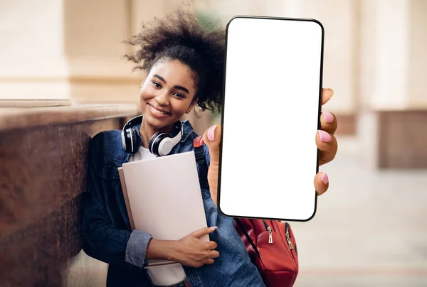 幸せなアフリカ系アメリカ人女性の学生が大きな空白の画面でスマートフォンを実証 — ストック写真