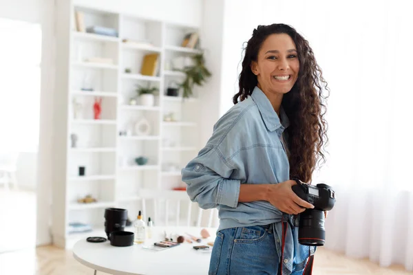 現代のスタジオに立つ女性写真家のポーズホールディング写真家 — ストック写真