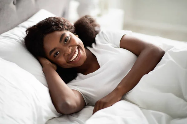 Primer plano de la foto de la señora bonita y feliz negro acostado en la cama —  Fotos de Stock