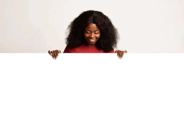 Mulher negra feliz olhando para baixo no espaço de cópia em branco Publicidade Board — Fotografia de Stock