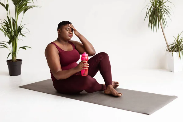 Agotado el sobrepeso negro dama sentado en fitness mat —  Fotos de Stock