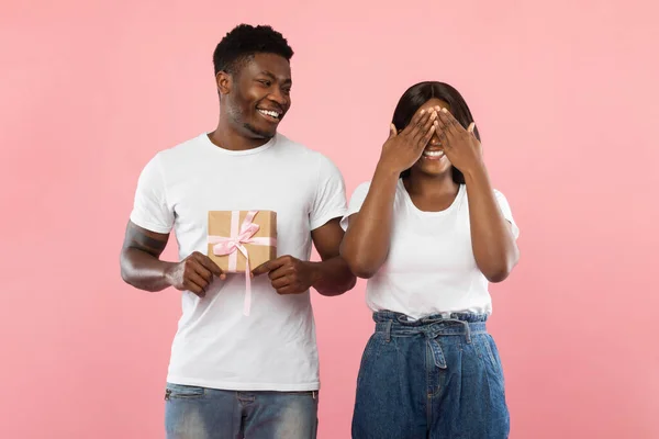 Feliz negro chico haciendo sorpresa para su mujer holding caja —  Fotos de Stock