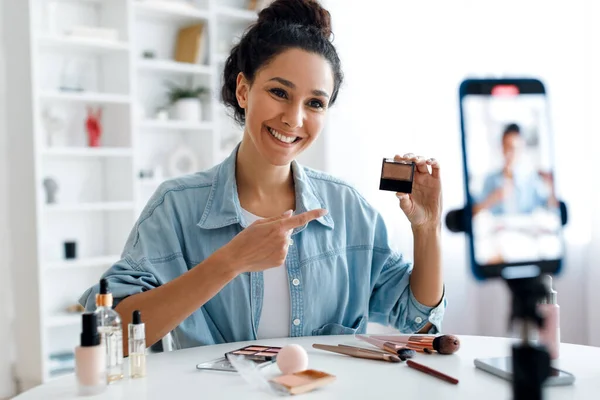 Lady Blogger mostrando el producto de maquillaje al teléfono haciendo video en interiores —  Fotos de Stock