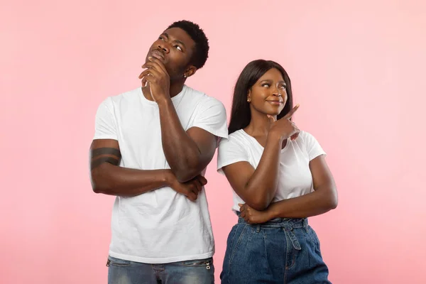 Hombre y mujer afroamericanos pensando en el fondo rosa —  Fotos de Stock