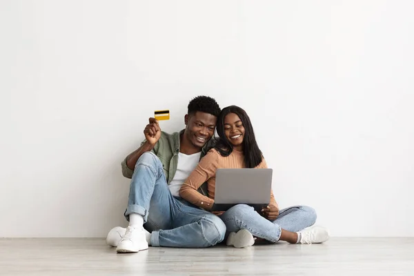Diz üstü bilgisayar ve kredi kartı kullanan neşeli Afro-Amerikan çift — Stok fotoğraf
