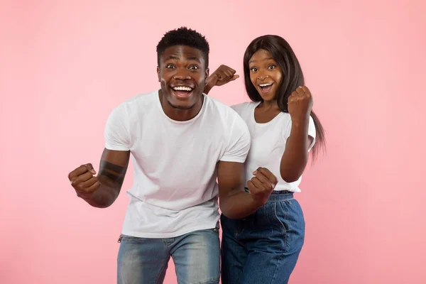 Retrato de pareja negra joven excitada agitando los puños cerrados —  Fotos de Stock