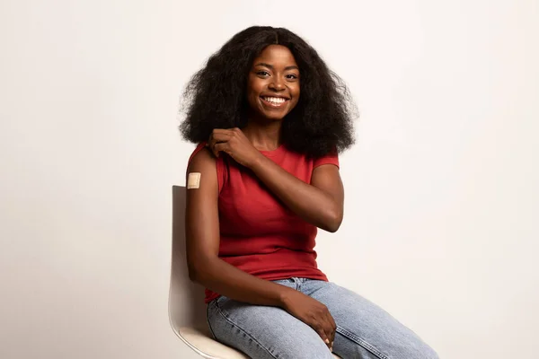 Campaña de vacunación. Brazo demostrativo alegre de la señora afroamericana con el vendaje adhesivo —  Fotos de Stock