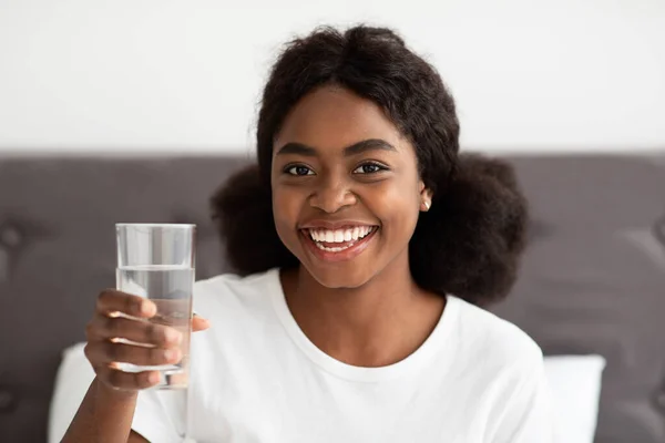 Primo piano di donna nera allegra che tiene il bicchiere d'acqua — Foto Stock