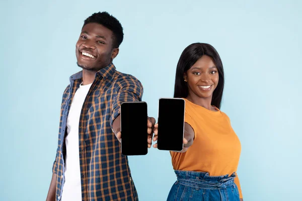 흑인 커플 이 흉내를 내기 위해 빈 스마트폰 화면 두 개를 보여 주고 있습니다. — 스톡 사진