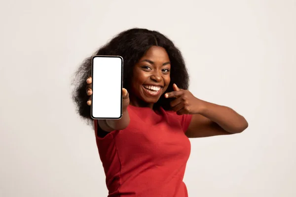 Check This Ad. Бодрая черная женщина держит и указывает на чистый смартфон — стоковое фото