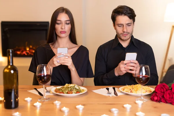 Nieszczęśliwa para przy użyciu telefonów komórkowych znudzona na randce — Zdjęcie stockowe