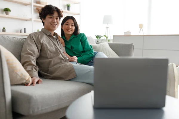Amour asiatique couple regarder film sur ordinateur portable, assis sur le canapé à la maison, espace libre — Photo