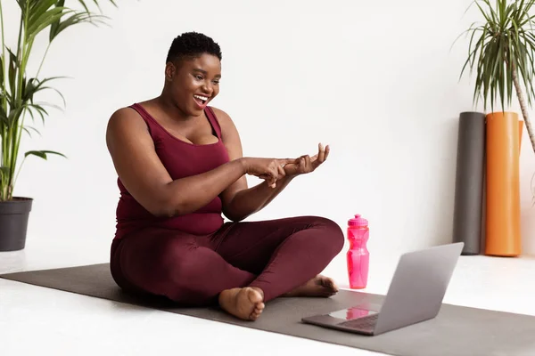 Alegre regordete negro mujer yoga entrenador streaming desde estudio —  Fotos de Stock