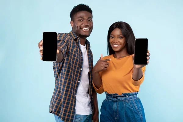 Pareja mostrando la pantalla vacía del teléfono inteligente en blanco para maqueta —  Fotos de Stock