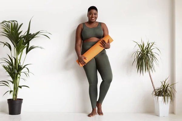 Mujer negra positiva más tamaño posando con colchoneta de fitness —  Fotos de Stock