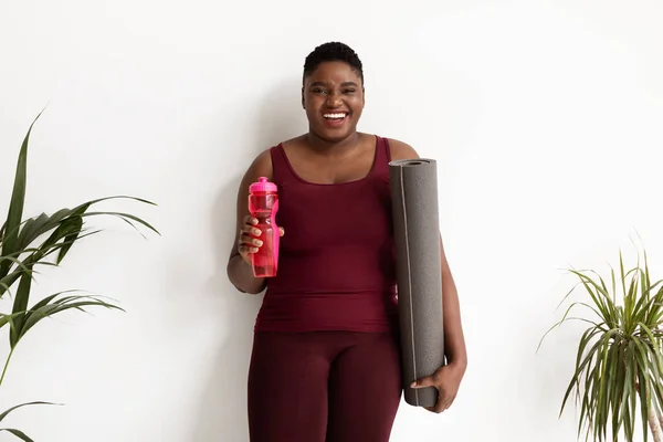 Mujer negra feliz más tamaño con botella de agua —  Fotos de Stock