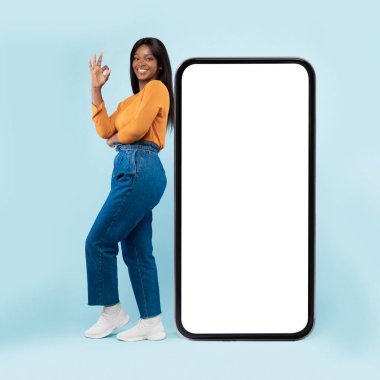 Siyah kadın beyaz, boş, akıllı telefon ekranına yaslanıyor.