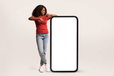 Reklam için yer. Pozitif Siyah Kadın Büyük Boş Akıllı Telefon Ekranını Gösteriyor