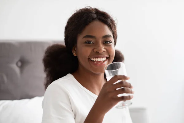 Saludable señora afroamericana bebiendo agua dulce después de despertar —  Fotos de Stock